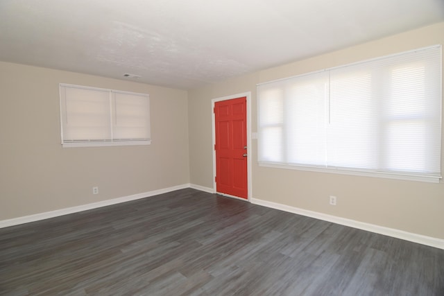 unfurnished room with dark wood-type flooring