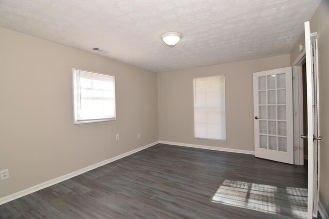 empty room featuring dark hardwood / wood-style floors and a textured ceiling