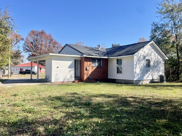 view of front of home with a carport, cooling unit, and a front lawn