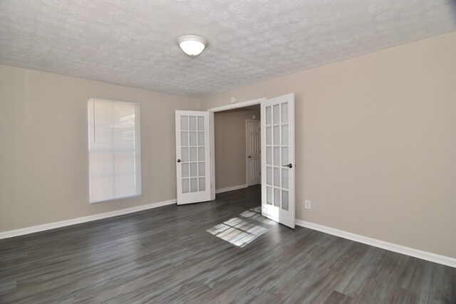 spare room with french doors, a textured ceiling, and dark hardwood / wood-style floors