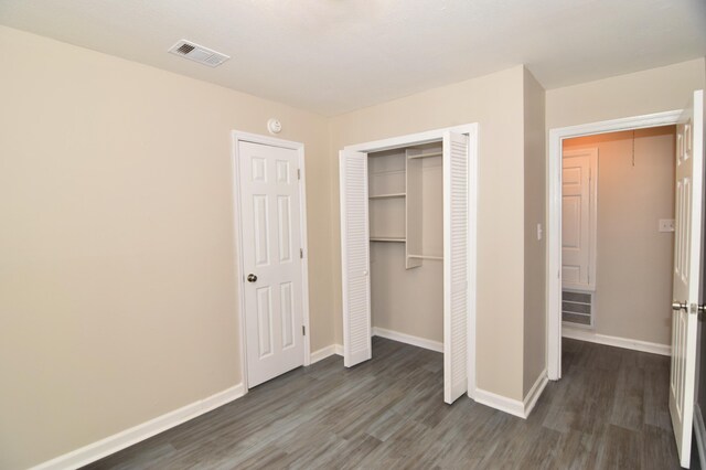 unfurnished bedroom with dark hardwood / wood-style flooring