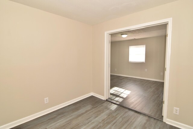 empty room with dark hardwood / wood-style flooring