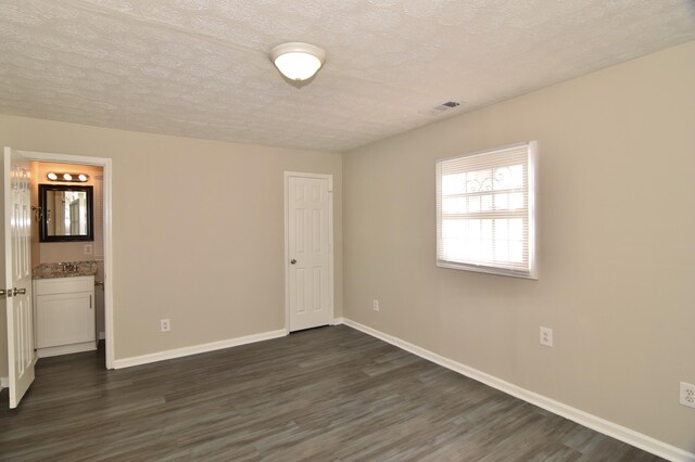 spare room with dark wood-type flooring and a textured ceiling