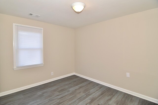 empty room with dark hardwood / wood-style flooring