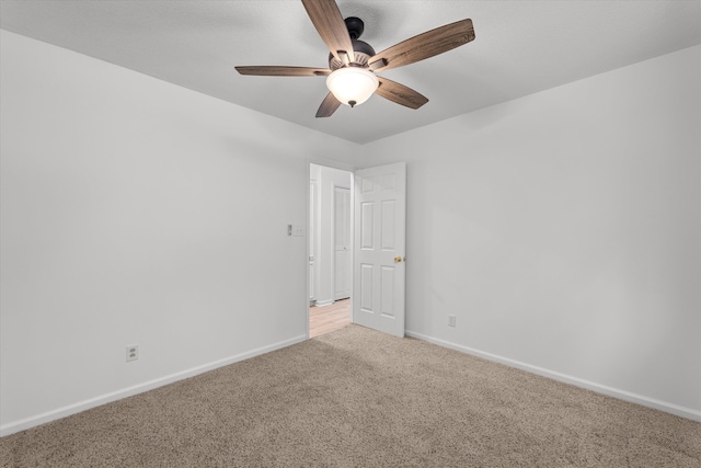 carpeted spare room with ceiling fan