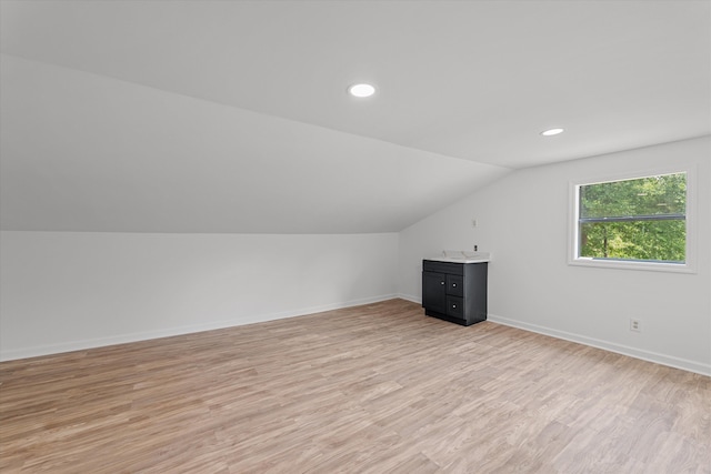 additional living space with light wood-type flooring and lofted ceiling