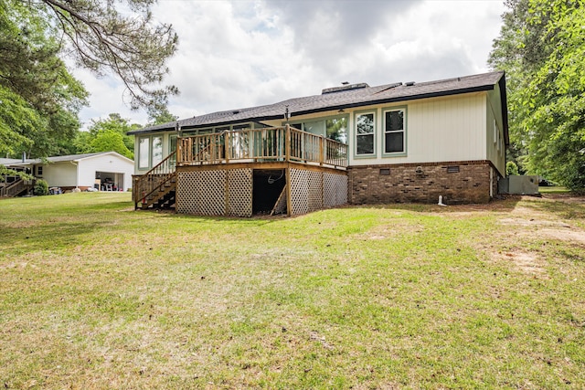 back of property with a wooden deck and a lawn