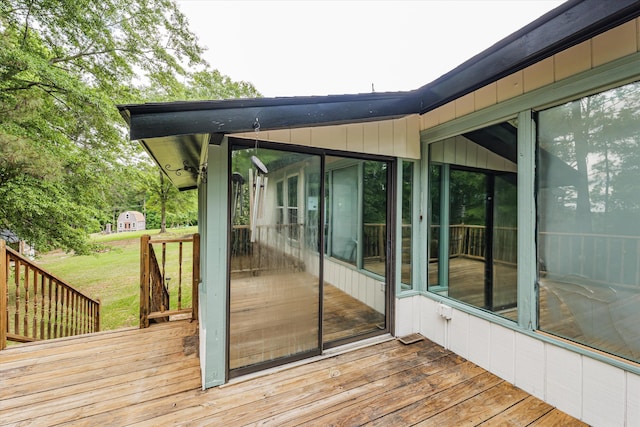 deck with a sunroom and a yard