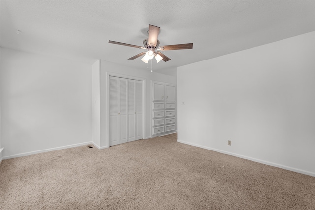 unfurnished bedroom featuring carpet flooring, ceiling fan, and a textured ceiling