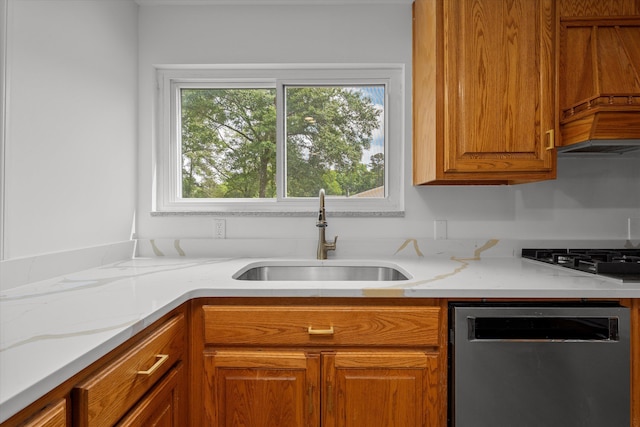 kitchen with dishwasher, gas stovetop, light stone countertops, and sink