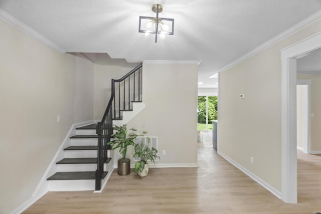 staircase featuring ornamental molding, a textured ceiling, and hardwood / wood-style flooring