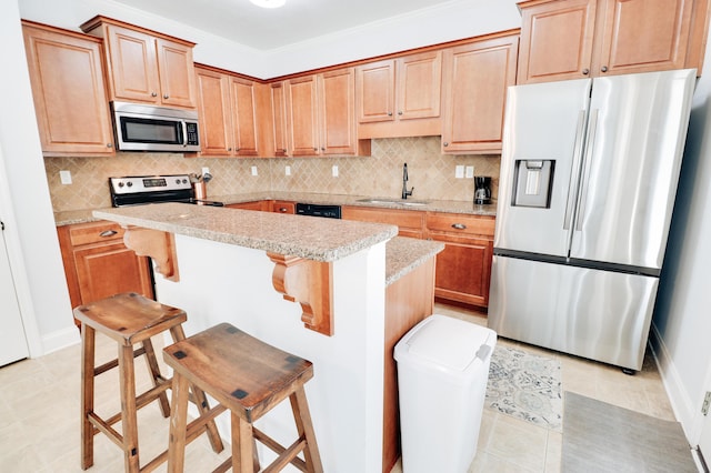 5553 Connor Dr, Evans, GA 30809 - kitchen with appliances with stainless steel finishes, decorative backsplash, a center island, and a kitchen bar