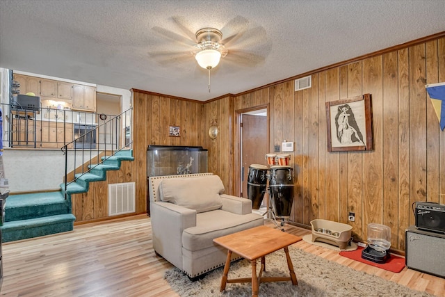 4056 Burning Tree Ln, Augusta, GA 30906 - living area featuring light wood finished floors, stairs, ceiling fan, wood walls, and crown molding