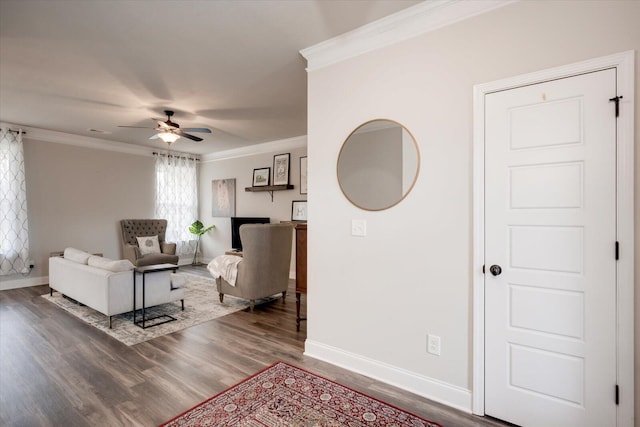 living room featuring hardwood / wood-style flooring, ceiling fan, and crown molding