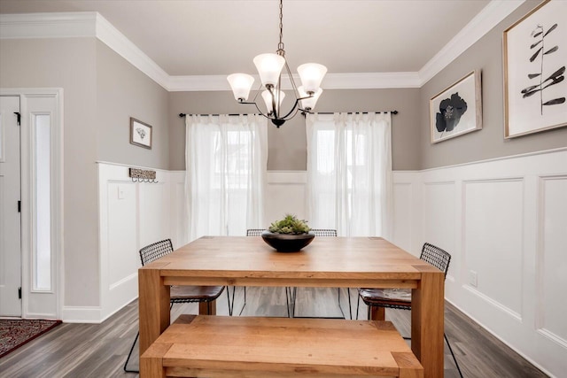 dining room featuring dark hardwood / wood-style flooring, crown molding, and an inviting chandelier