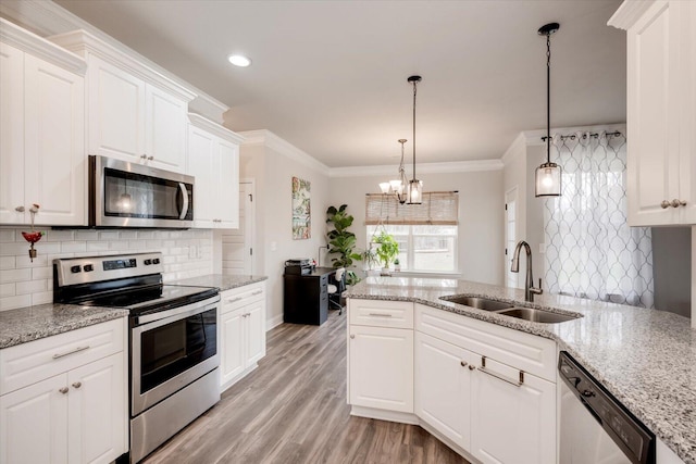 kitchen featuring white cabinetry, sink, stainless steel appliances, a chandelier, and pendant lighting