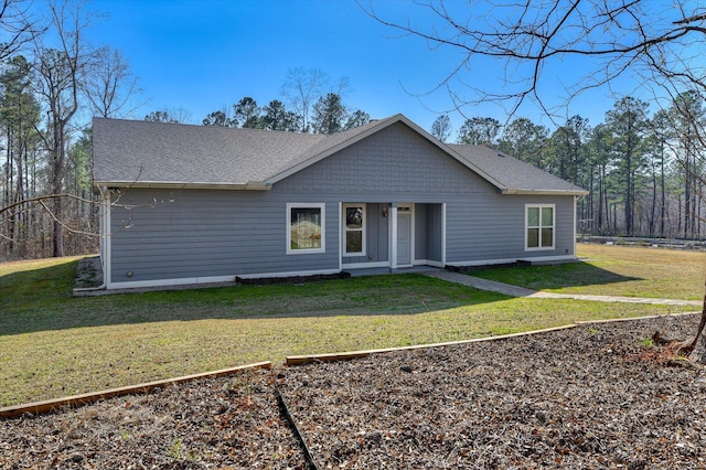 view of front facade with a front lawn and roof with shingles