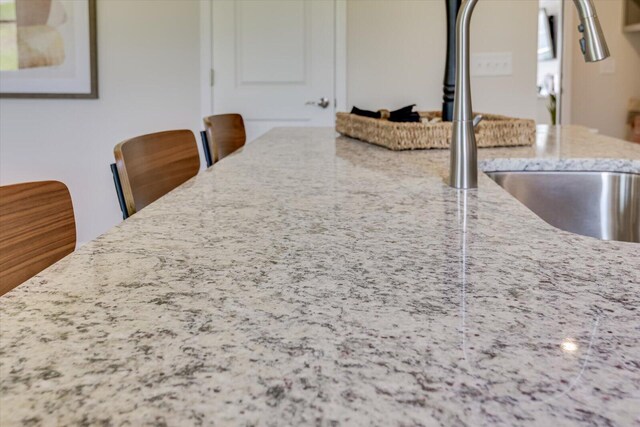 interior space with a sink and light stone countertops