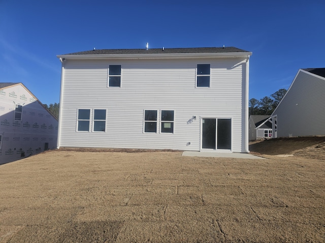 rear view of property featuring a lawn