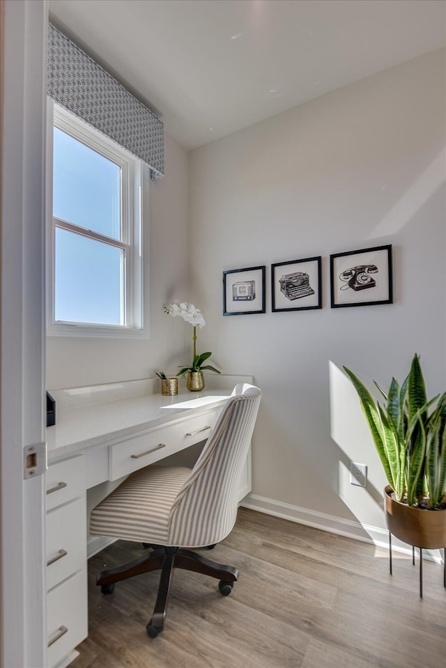 home office featuring built in desk and light wood-type flooring