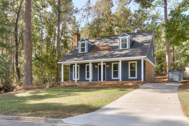 new england style home featuring a porch and a front yard