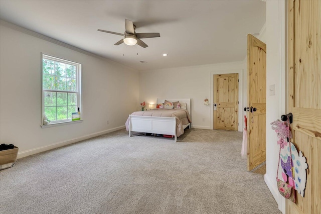 carpeted bedroom with ceiling fan and ornamental molding