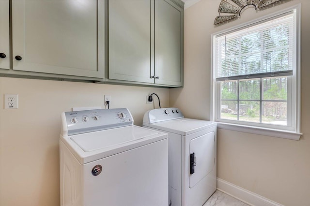 laundry area with washer and dryer and cabinets