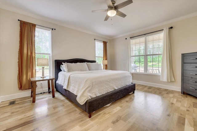 bedroom with ceiling fan, light wood-type flooring, and ornamental molding