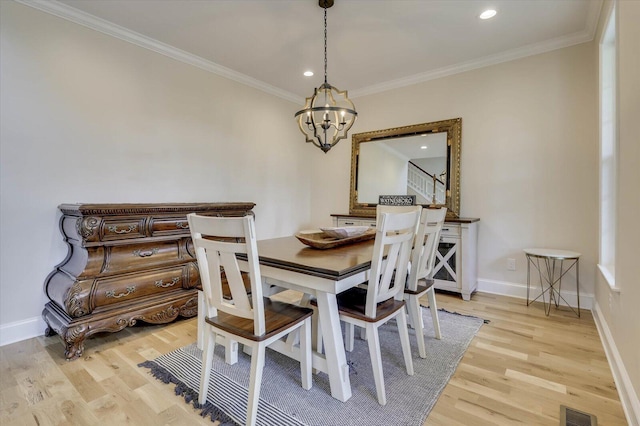 dining space featuring ornamental molding, a chandelier, and light wood-type flooring