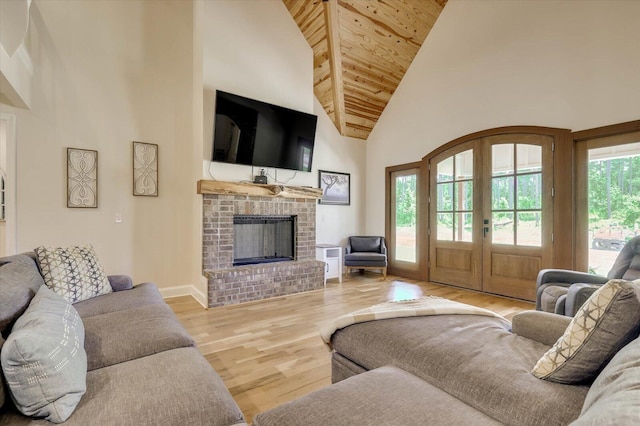 living room with wooden ceiling, high vaulted ceiling, french doors, light hardwood / wood-style flooring, and a fireplace