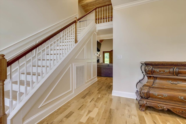 stairway featuring hardwood / wood-style flooring and ornamental molding