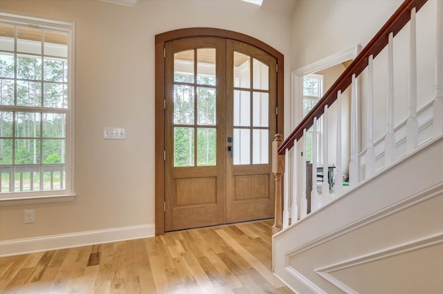 entryway featuring a healthy amount of sunlight, light wood-type flooring, and french doors