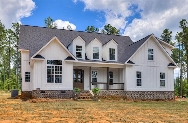 view of front of house with central AC unit, a porch, and a front lawn