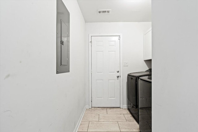 laundry area featuring cabinets, washing machine and dryer, electric panel, and light tile patterned flooring