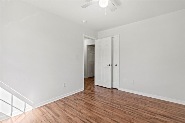 empty room featuring ceiling fan and dark wood-type flooring