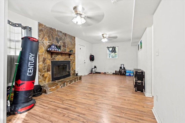 living room featuring a fireplace, hardwood / wood-style floors, and ceiling fan