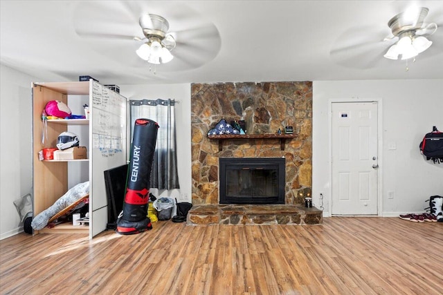 living room featuring a fireplace, ceiling fan, and hardwood / wood-style floors