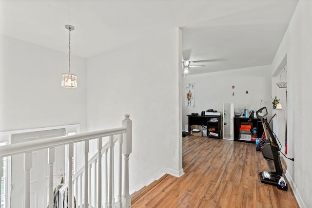 hall featuring wood-type flooring and an inviting chandelier