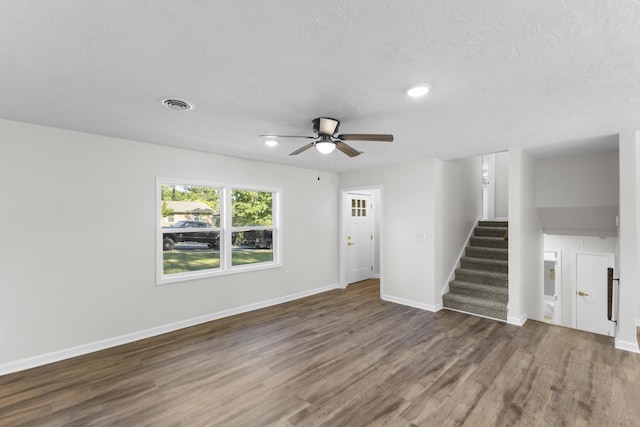 319 Indian Trl, Augusta, GA 30907 - unfurnished living room featuring wood finished floors, ceiling fan, stairway, baseboards, and a textured ceiling