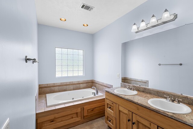 full bath with a sink, a jetted tub, and tile patterned flooring