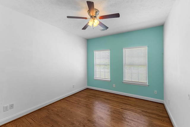 unfurnished room with wood finished floors, baseboards, a ceiling fan, and a textured ceiling