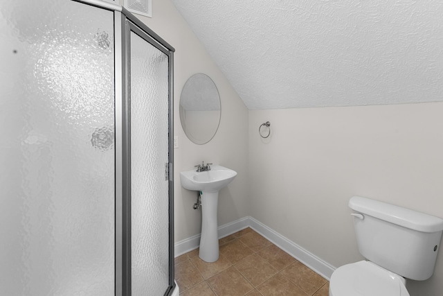 full bath with lofted ceiling, tile patterned floors, a shower stall, toilet, and a textured ceiling