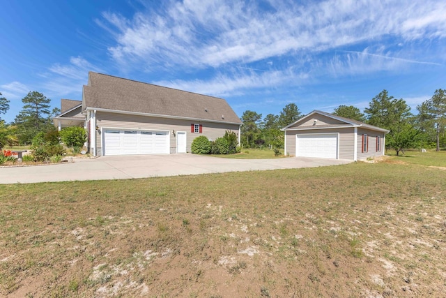 single story home featuring a front yard, an outdoor structure, and a garage