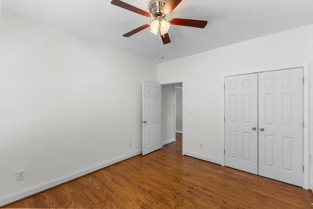 unfurnished bedroom with light wood-style flooring, baseboards, a ceiling fan, and a closet