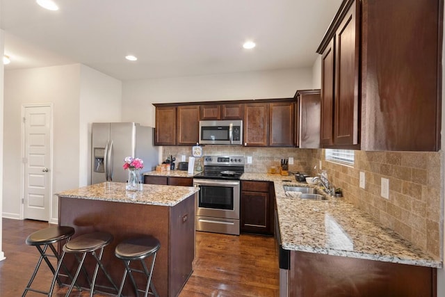 108 Sims Ct, Augusta, GA 30909 - kitchen featuring stainless steel appliances, a kitchen island, tasteful backsplash, dark wood-type flooring, and a kitchen bar