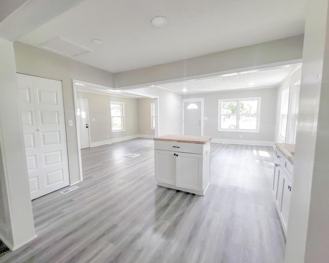 kitchen featuring a center island, light hardwood / wood-style flooring, white cabinetry, and a healthy amount of sunlight