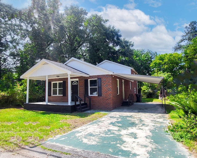 view of front of house with a front yard, a carport, and covered porch