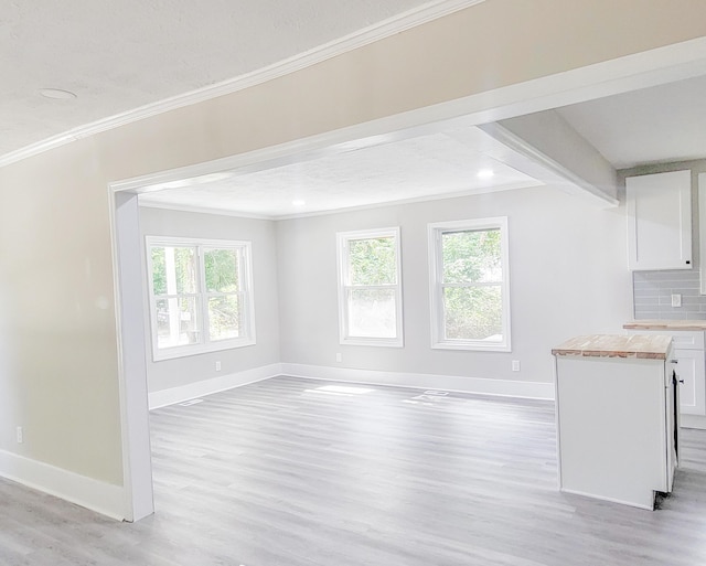 unfurnished living room featuring light wood-type flooring and ornamental molding