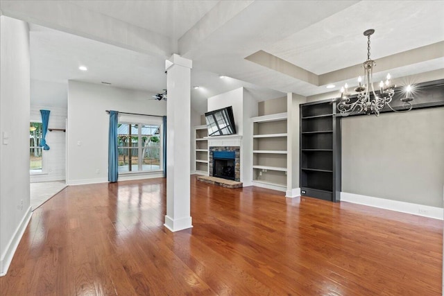 459 Sebastian Dr, Grovetown, GA 30813 - unfurnished living room with built in shelves, wood finished floors, a chandelier, a stone fireplace, and recessed lighting