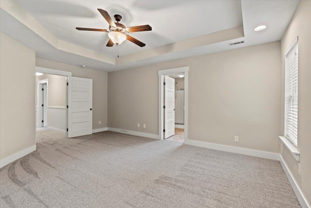 459 Sebastian Dr, Grovetown, GA 30813 - unfurnished bedroom featuring a tray ceiling, carpet, multiple windows, and ensuite bathroom